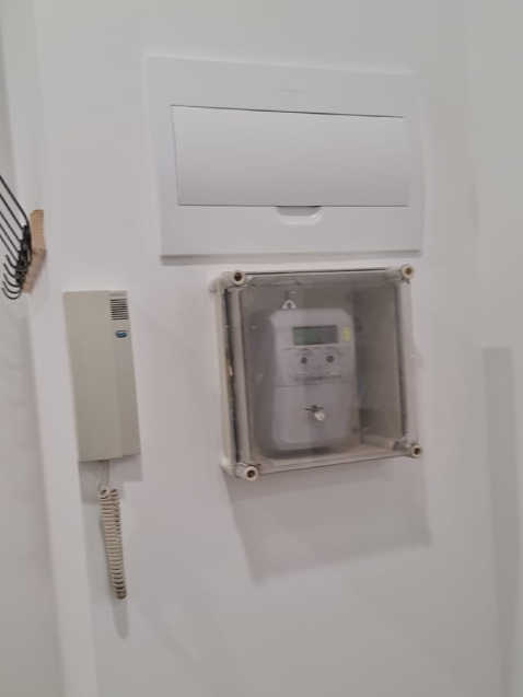 Contador eléctrico cubierto en la pared blanca