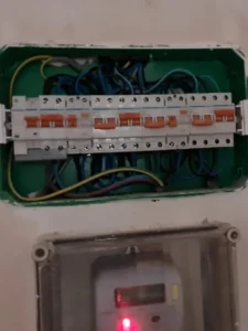Caja eléctrica con interruptores y cables visibles.
