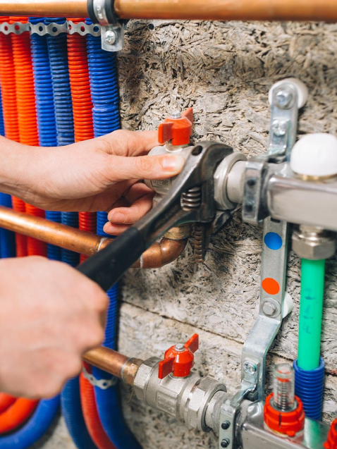 Persona ajustando tuberías con llave inglesa