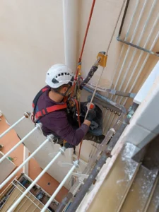 Trabajador limpiando ventanas con equipo de seguridad