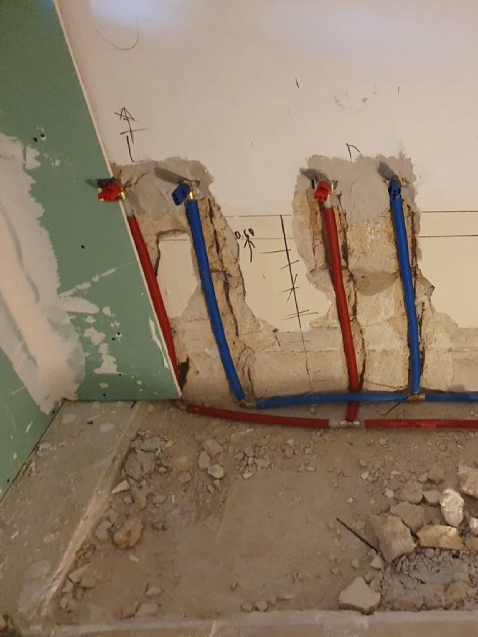 Tuberías de agua expuestas en pared en renovación