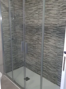 Ducha moderna con azulejos grises y puerta corrediza