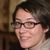 Mujer con gafas sonriendo, fondo desenfocado
