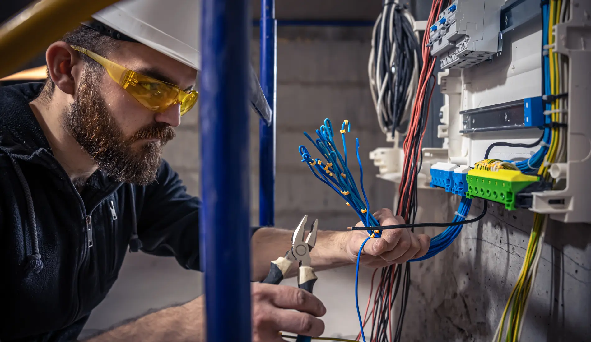 Electricista trabajando en cuadro eléctrico con cables